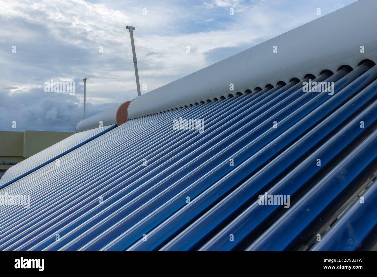 pannelli solari e tubi installati sui tetti della casa e. costruzione di piani per risparmiare energia per il riscaldamento dell'acqua Foto Stock