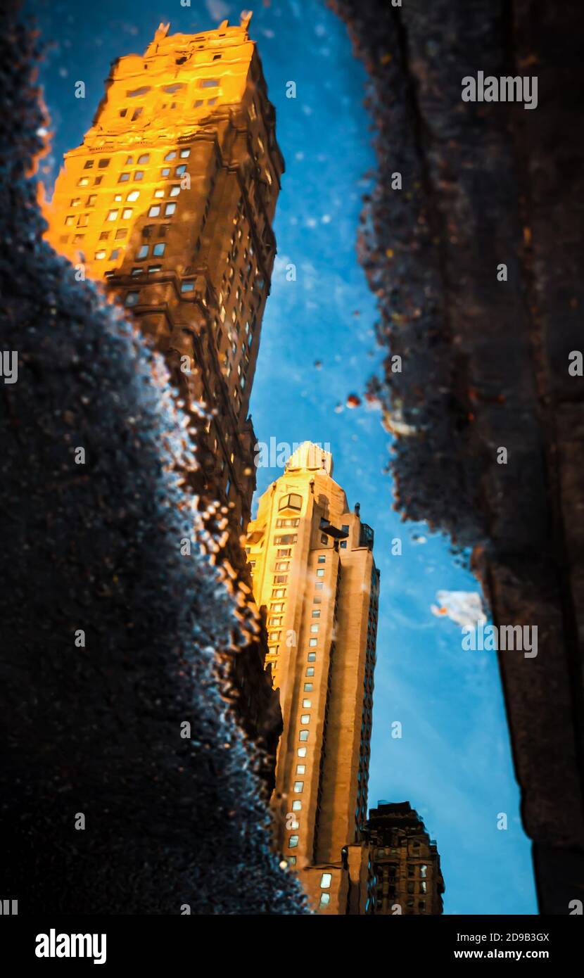I grattacieli riflettono in pozzanghere sulle strade di Manhattan Foto Stock