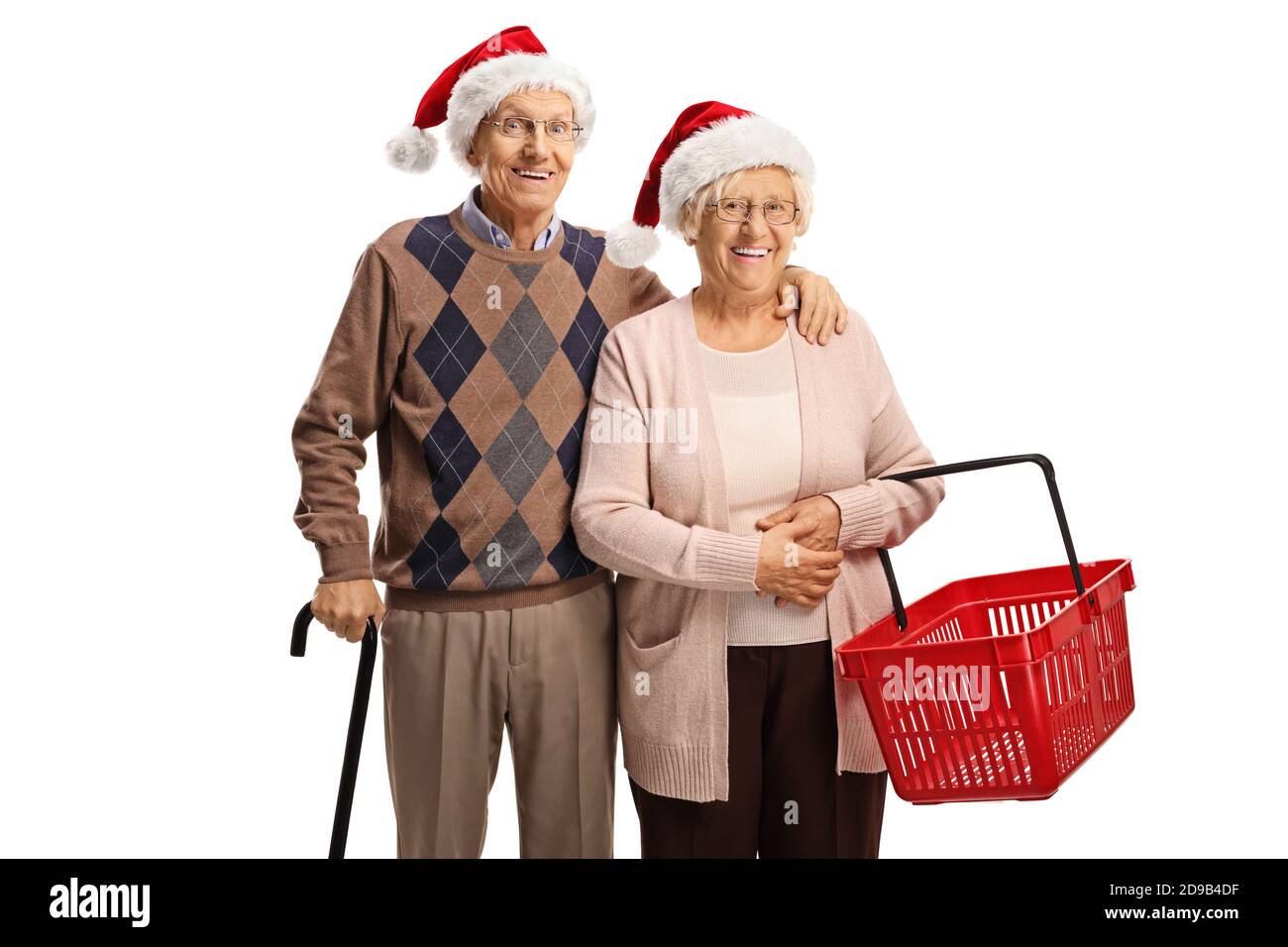 Felice coppia anziana con un cestino vuoto che indossa babbo natale cappelli claus isolati su sfondo bianco Foto Stock