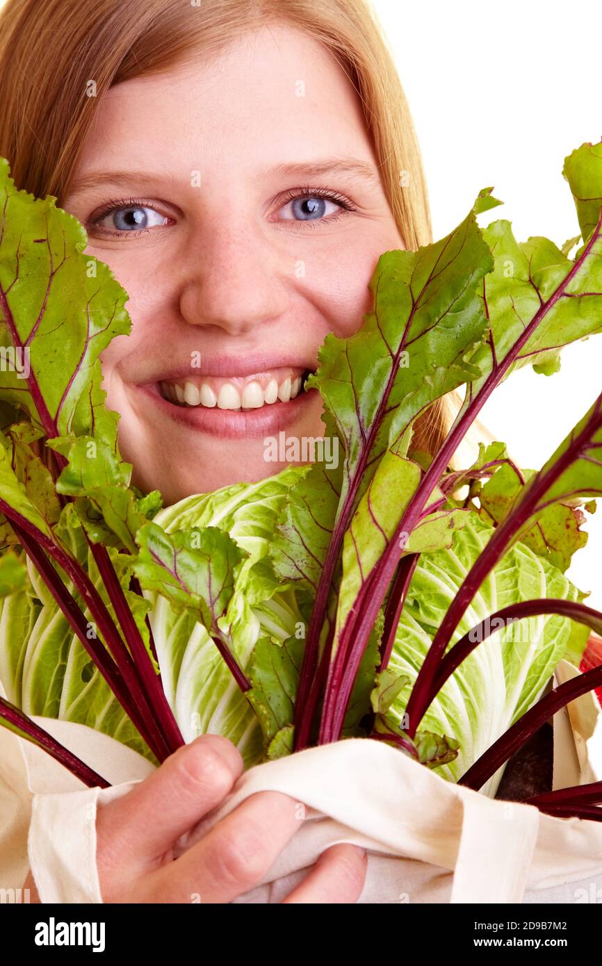 Donna bionda con barbabietola (Beta vulgaris subsp. Vulgaris var. Condiativa) in borsa Foto Stock