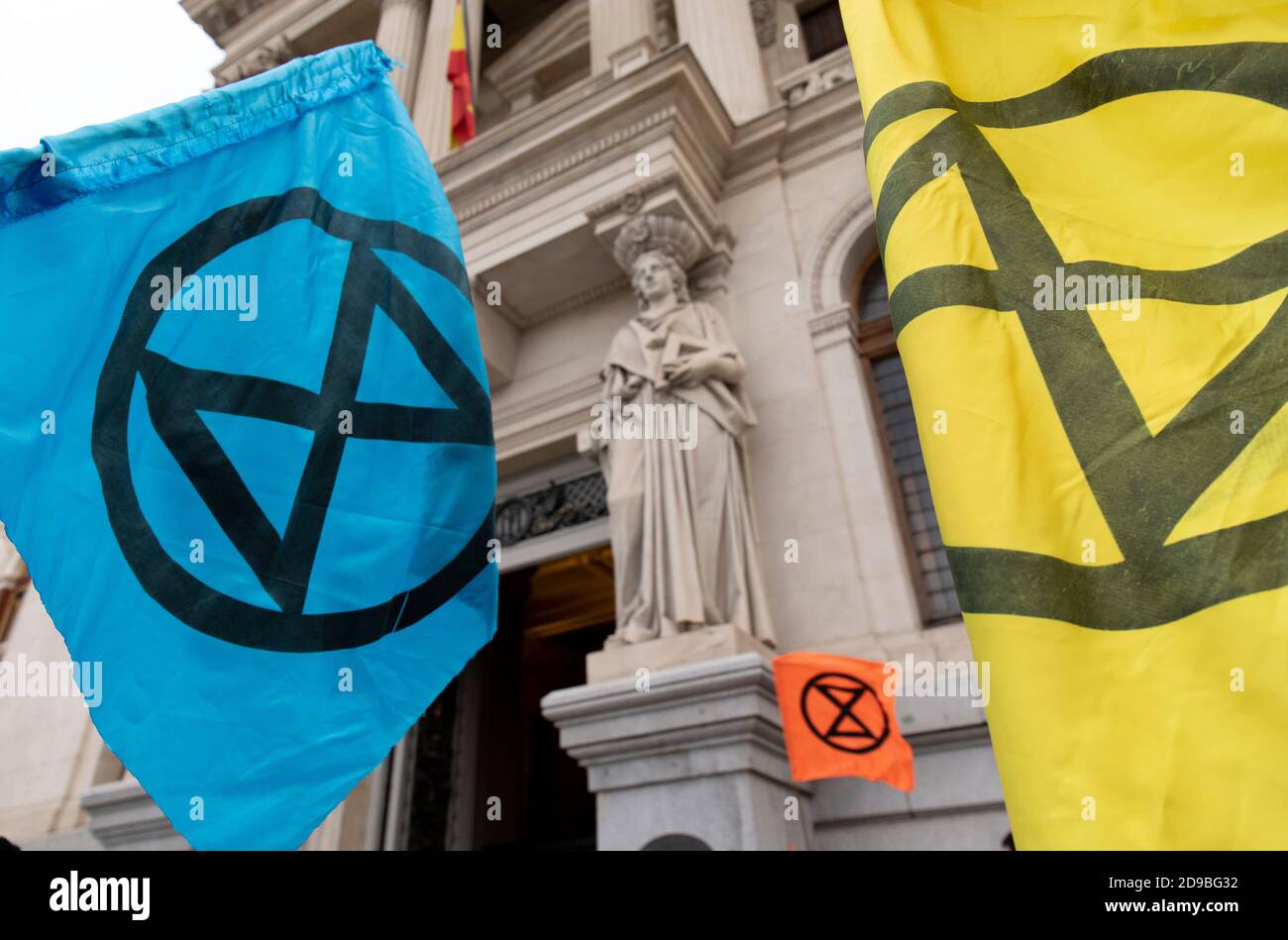 Due bandiere di ribellione per l'estinzione sono viste di fronte ad una delle statue del Ministero dell'Agricoltura di Madrid. Durante la terza ribellione internazionale, il movimento di ribellione per l'estinzione ha bloccato l'ingresso del Ministero dell'Agricoltura questa mattina per rivendicare la protezione della biodiversità a Madrid. Foto Stock