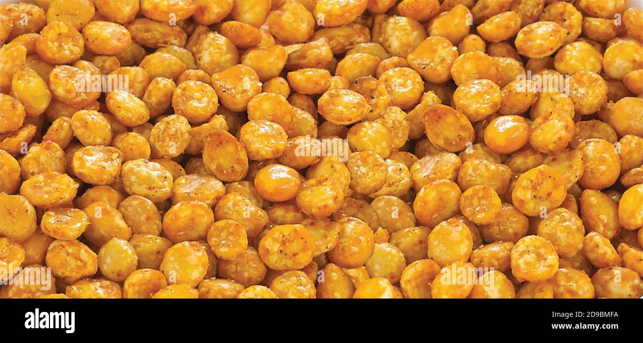 Il Chana dal fritto e speziato è uno spuntino gujarati molto popolare, ciotola bianca su sfondo bianco, sacchetto che impacchettano lo spuntino di strada comune dall'India, selettivo Foto Stock