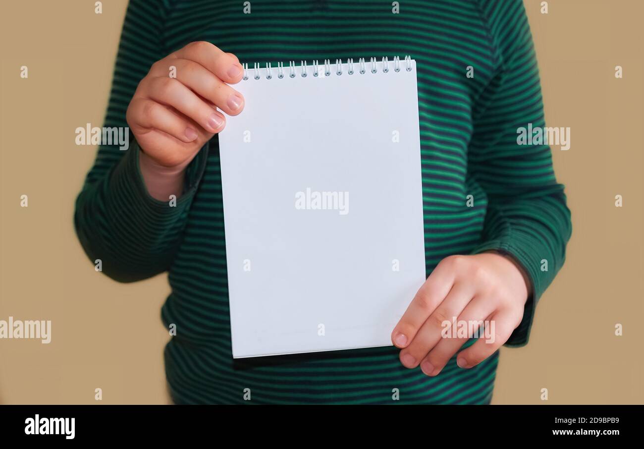 Le mani dei bambini tengono una busta bianca vuota. Primo piano. Spazio per il testo Foto Stock