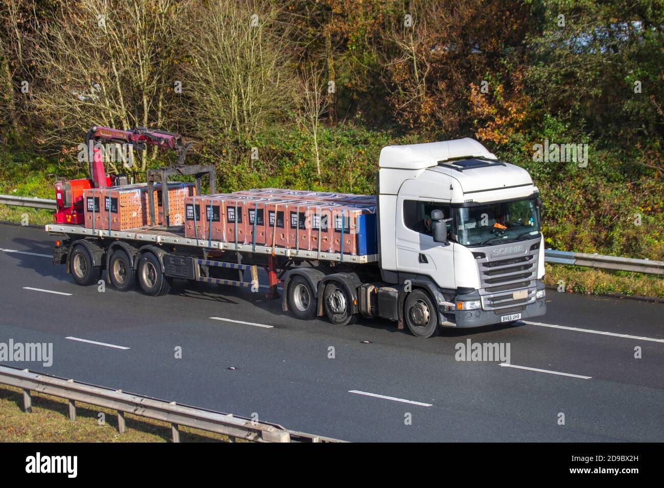 Trasporti, autocarri con caricatore basso, veicoli pesanti, trasporti, autocarri, cargo, veicoli Scania, industria europea del trasporto commerciale HGV, M61 a Manchester, Regno Unito Foto Stock