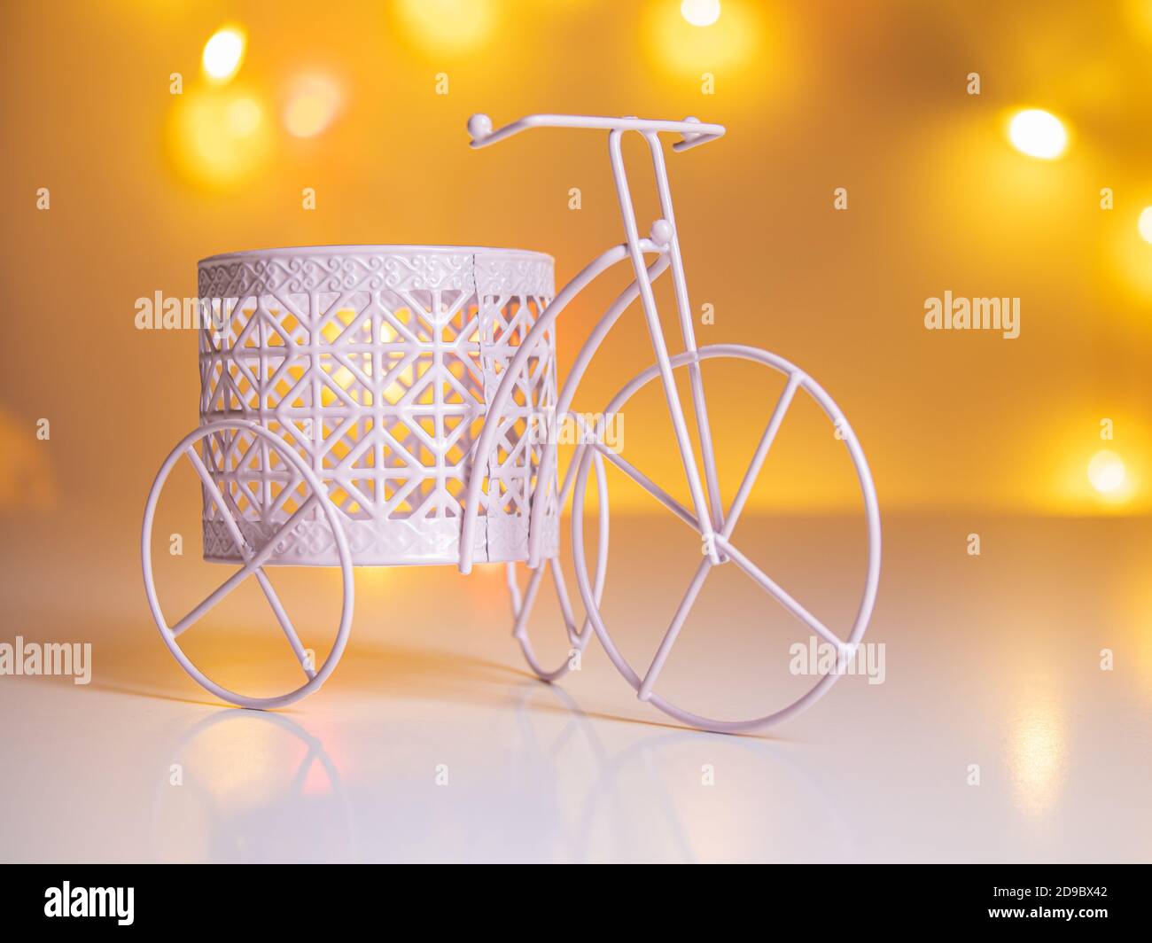 triciclo decorativo con un cesto sullo sfondo di sfocato luci Foto Stock