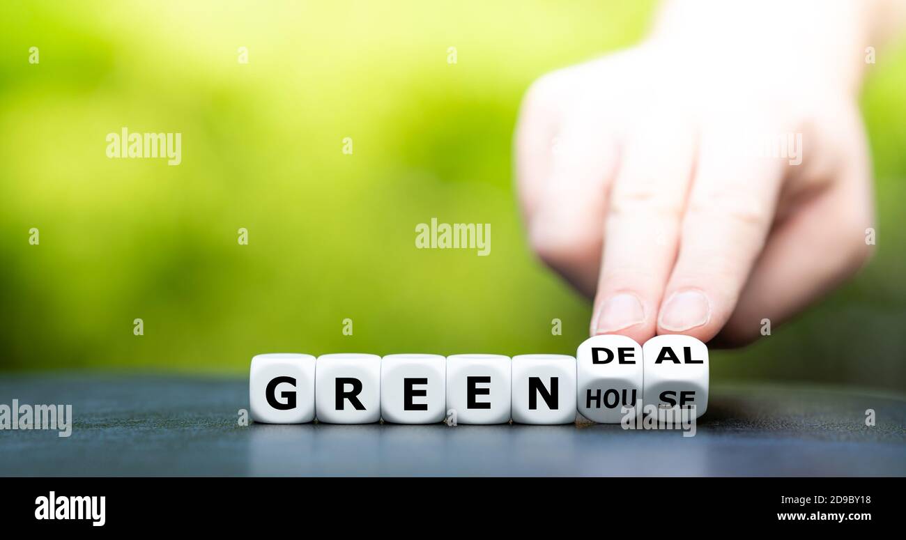 La mano trasforma i dadi e cambia l'espressione "serra" in "affare verde". Foto Stock