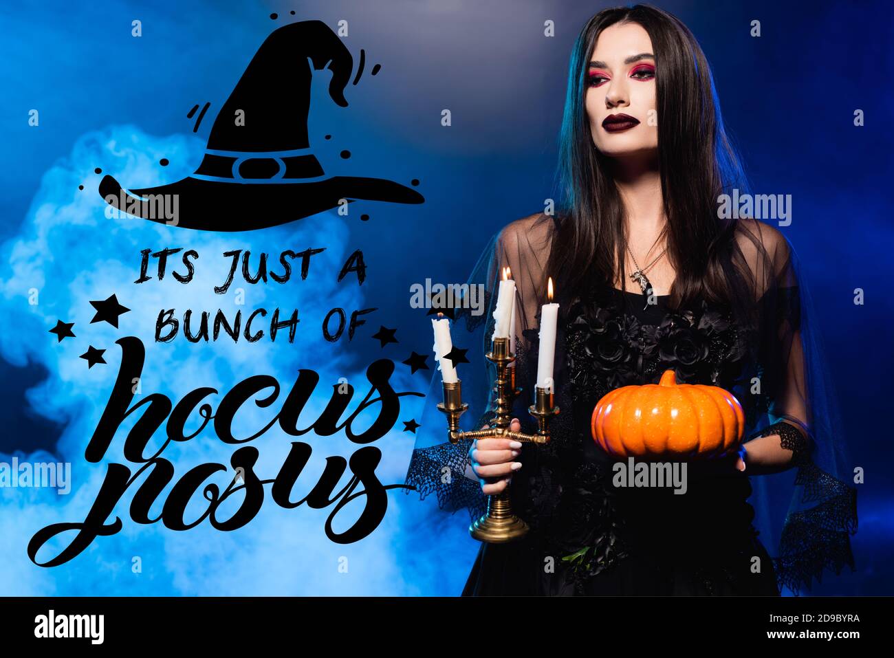 donna in abito nero e velo che tiene la zucca e bruciando candele vicino è giusto mazzo di hocus pocus lettering su blu con fumo Foto Stock