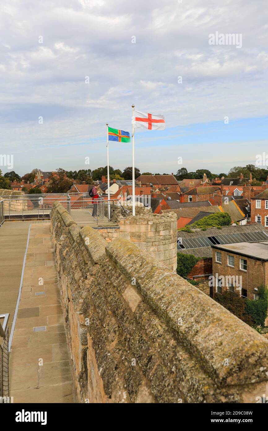 Bandiere che volano sul passaggio pedonale alle mura del castello di Lincoln, Città di Lincoln, Lincolnshire, Inghilterra, Regno Unito Foto Stock