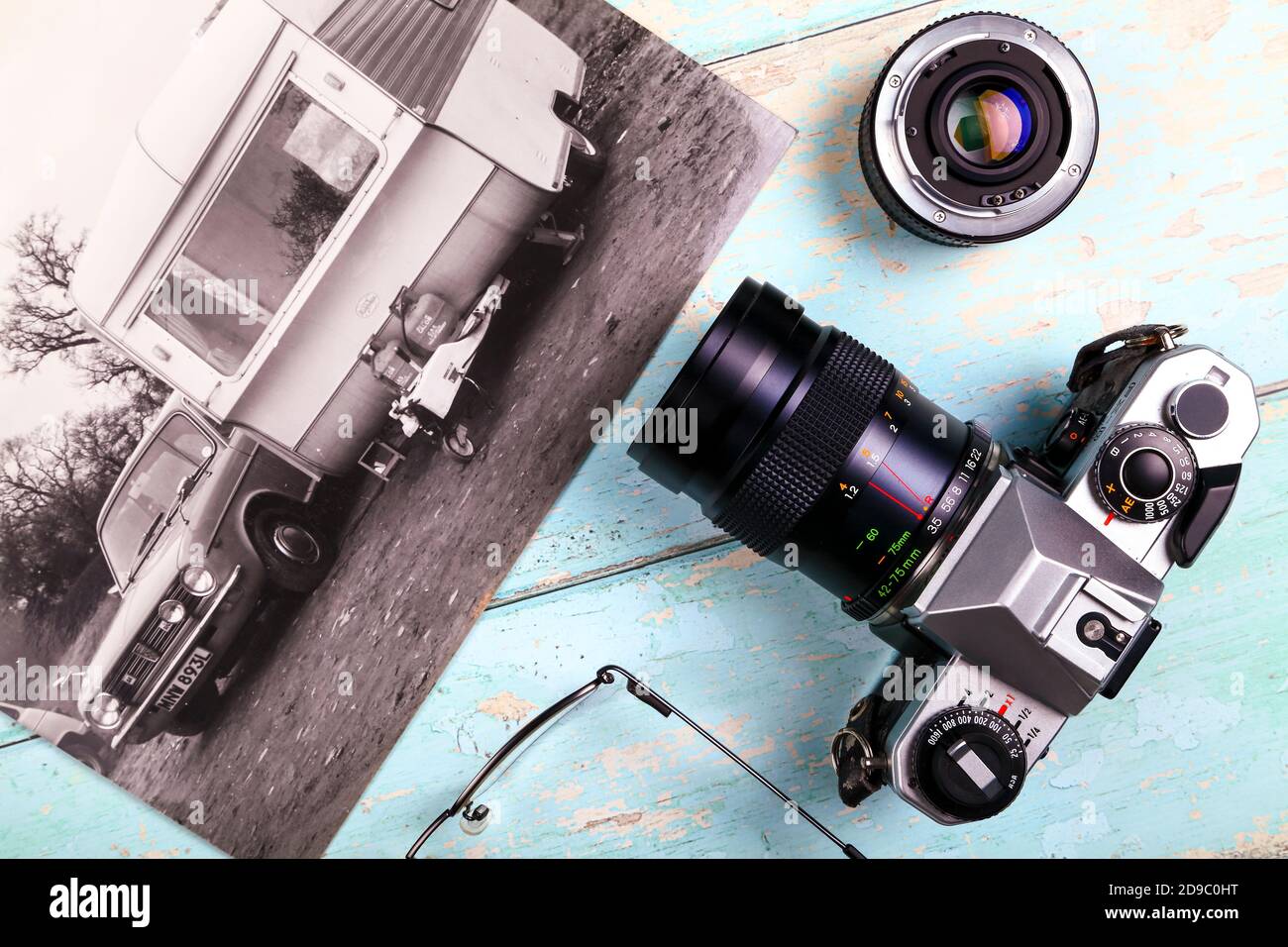 Vecchia fotocamera reflex vintage e obiettivo con un nero e fotografia bianca dei primi anni '70 di un 1972 regg Austin Maxi auto e caravan Foto Stock