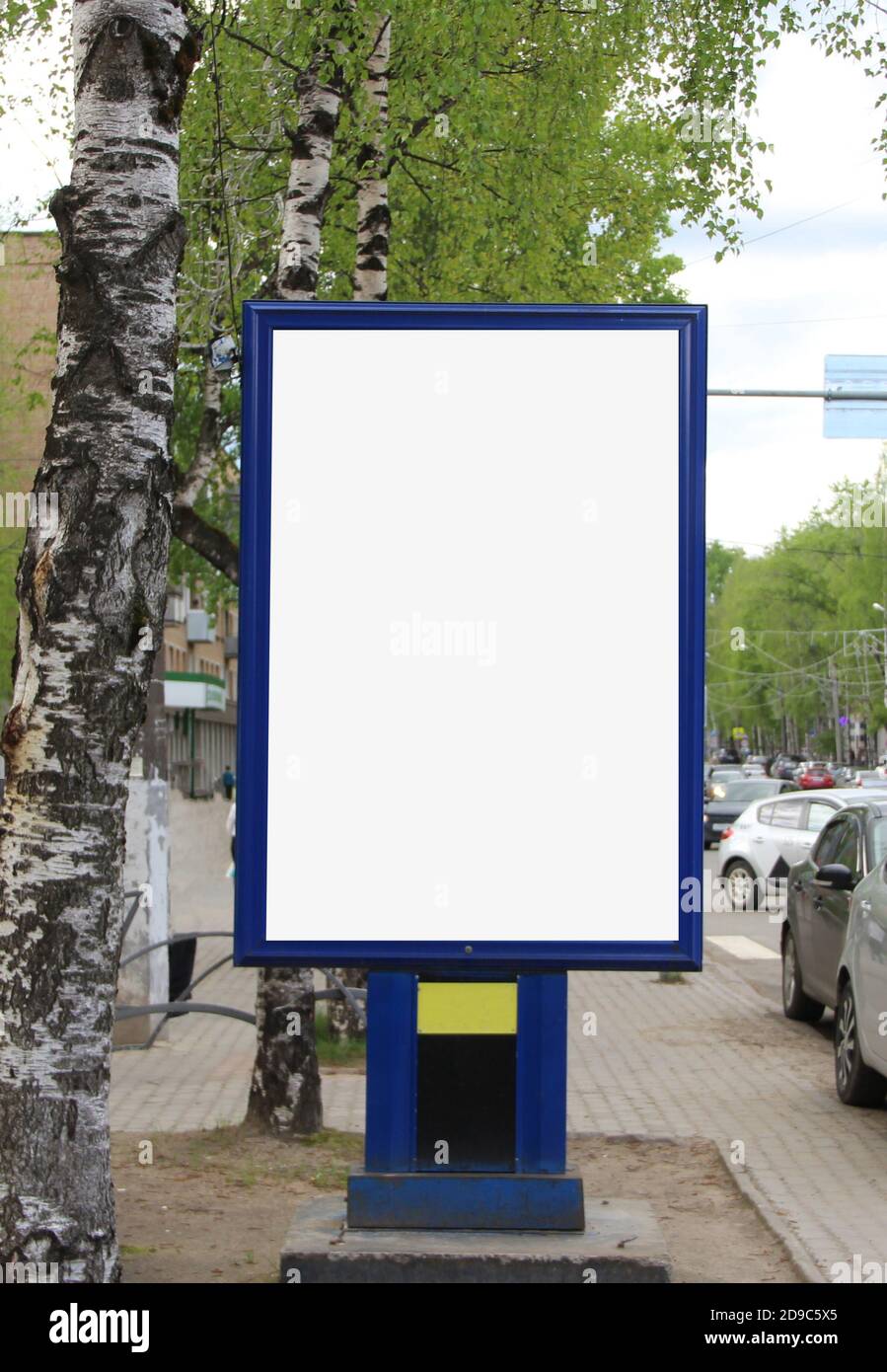 Design pubblicitario con stucco rettangolare verticale bianco. Un banner in città in estate. Un cartellone con un posto per lo spazio di testo e di copia. Foto Stock