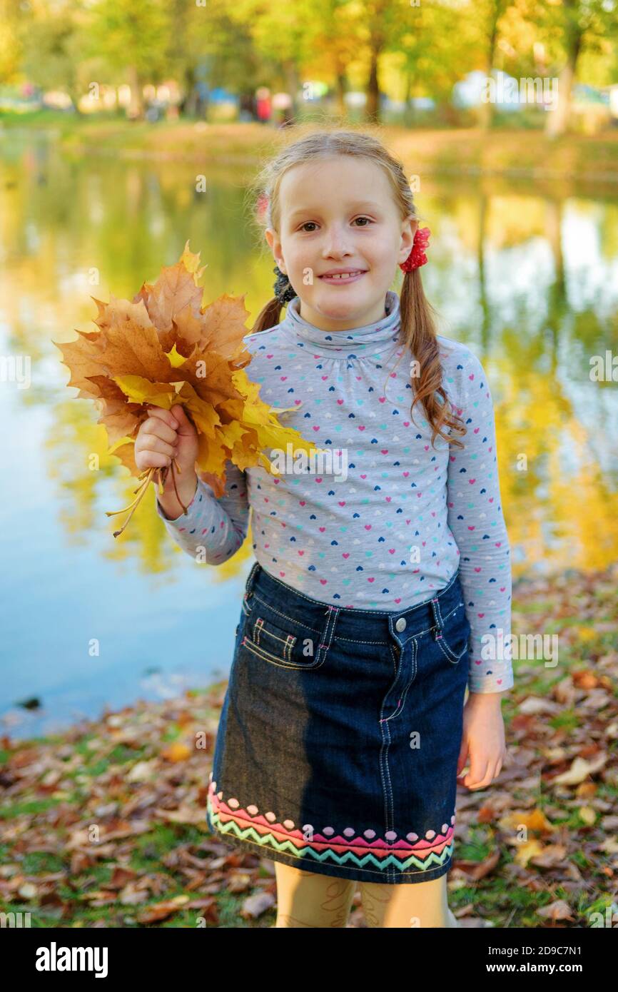 La famiglia felice avendo divertimento nel parco di autunno Foto Stock