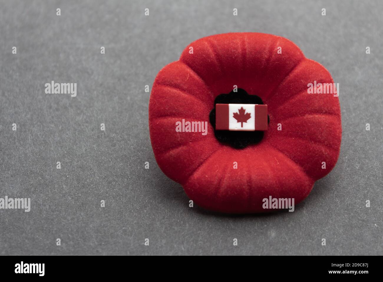 Papavero canadese per il giorno della memoria con la bandiera del Canada pin sopra sfondo scuro Foto Stock