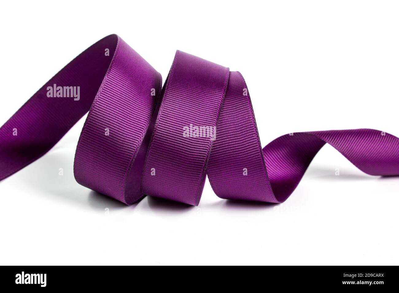 Ricci di viola bello seta satinata nastro di festa su uno sfondo bianco. Copia spazio per il testo. Foto Stock