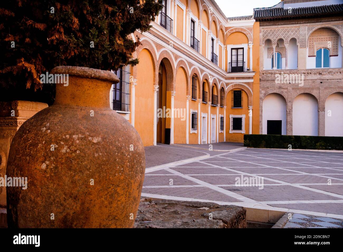 Archi romanici e moreschi e cortile in mattoni del Patio de las Monteria al Royal Alcázar di Siviglia, Spagna. Foto Stock