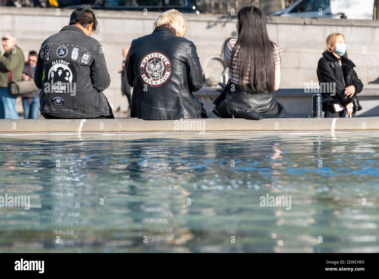 Rocker in giacche di pelle nera seduti sulla fontana di Trafalgar Square il giorno soleggiato di novembre, l'ultimo giorno prima del blocco COVID 19 2. Ventola della testa del motore Foto Stock