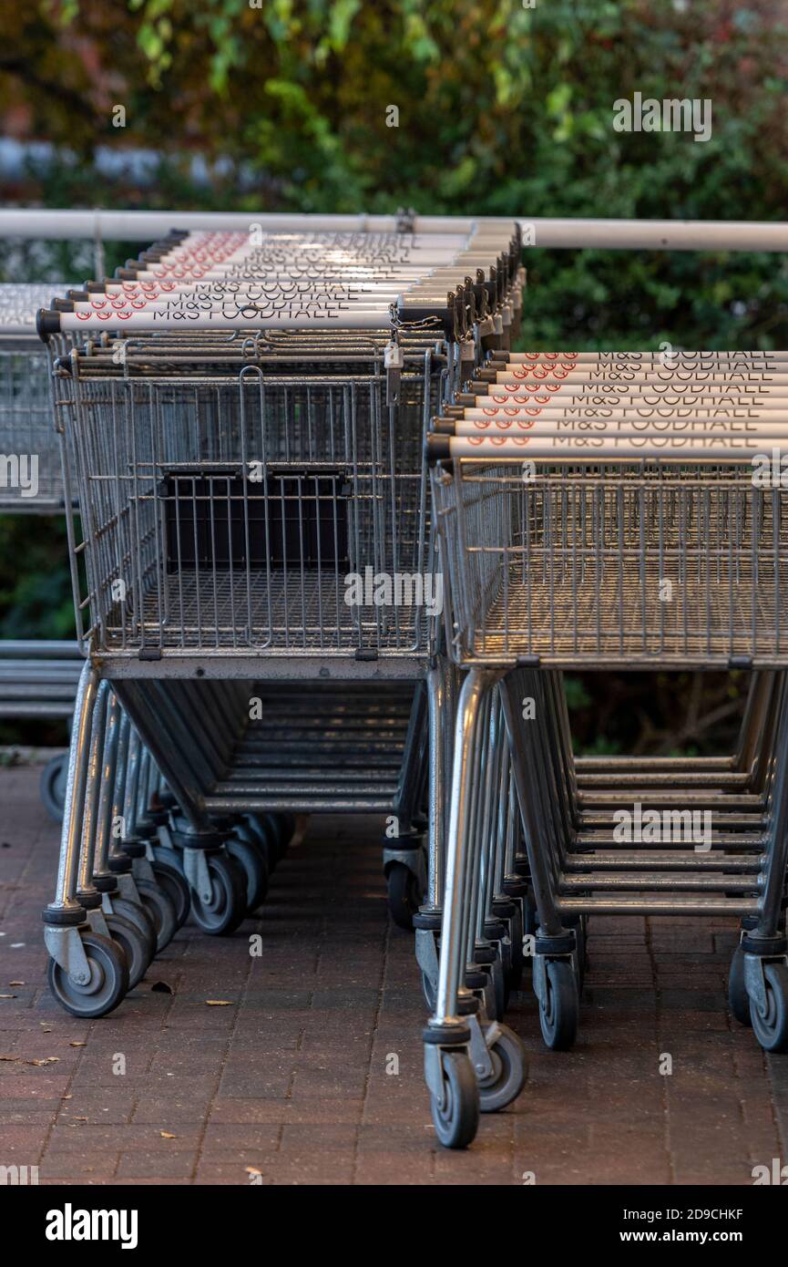 carrello per lo shopping in file e impilato all'esterno di un supermercato in attesa di uso. Foto Stock