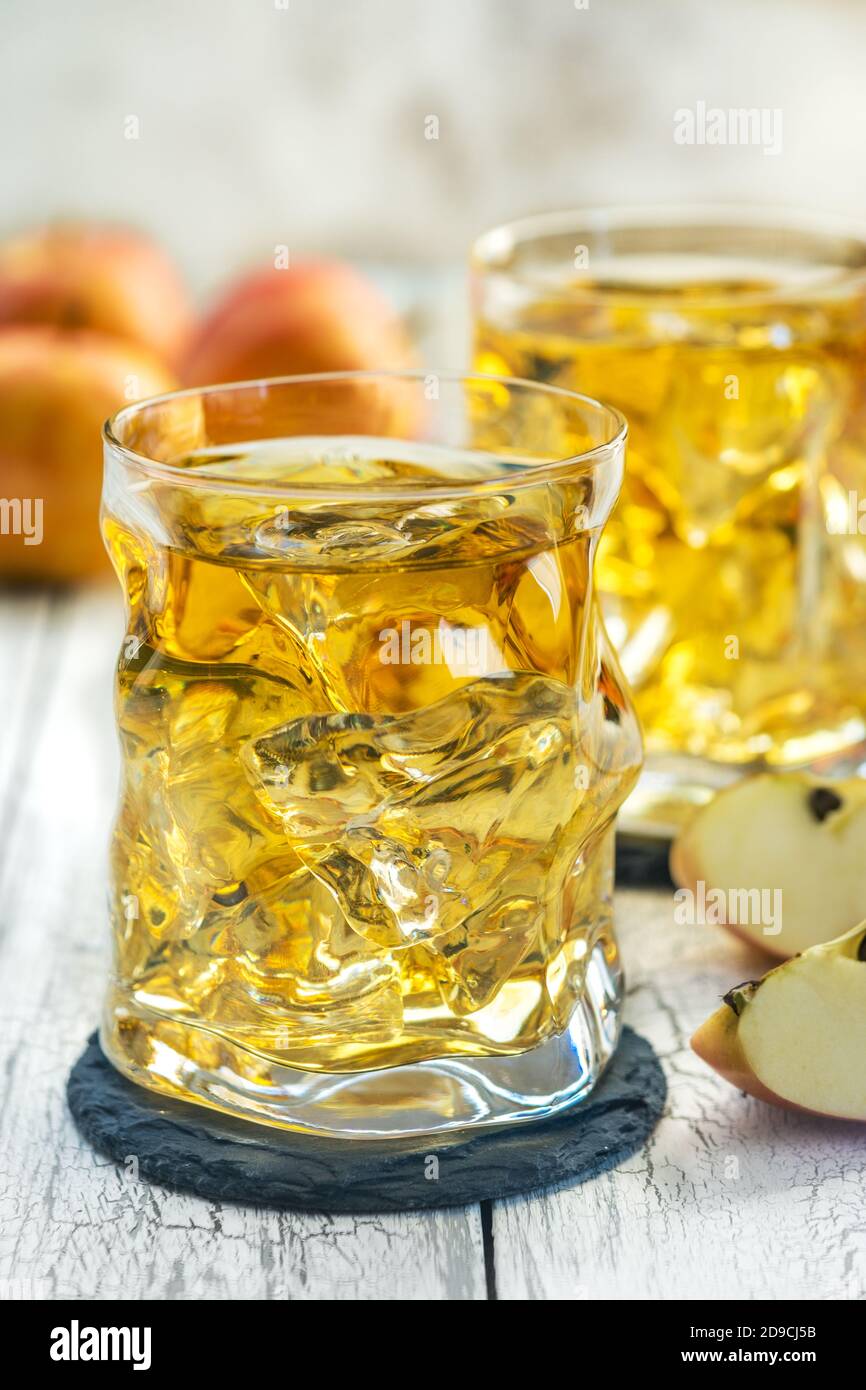 Bicchiere di succo di mela con ghiaccio e mela rossa fresca Foto Stock