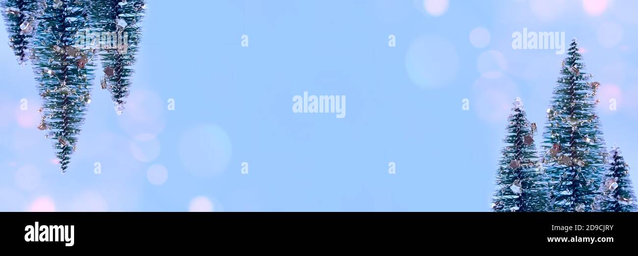Trendy sfondo banner di Natale - albero di Natale o Capodanno albero con decorazioni e luci bokeh su sfondo blu alla moda con copyspace per Foto Stock