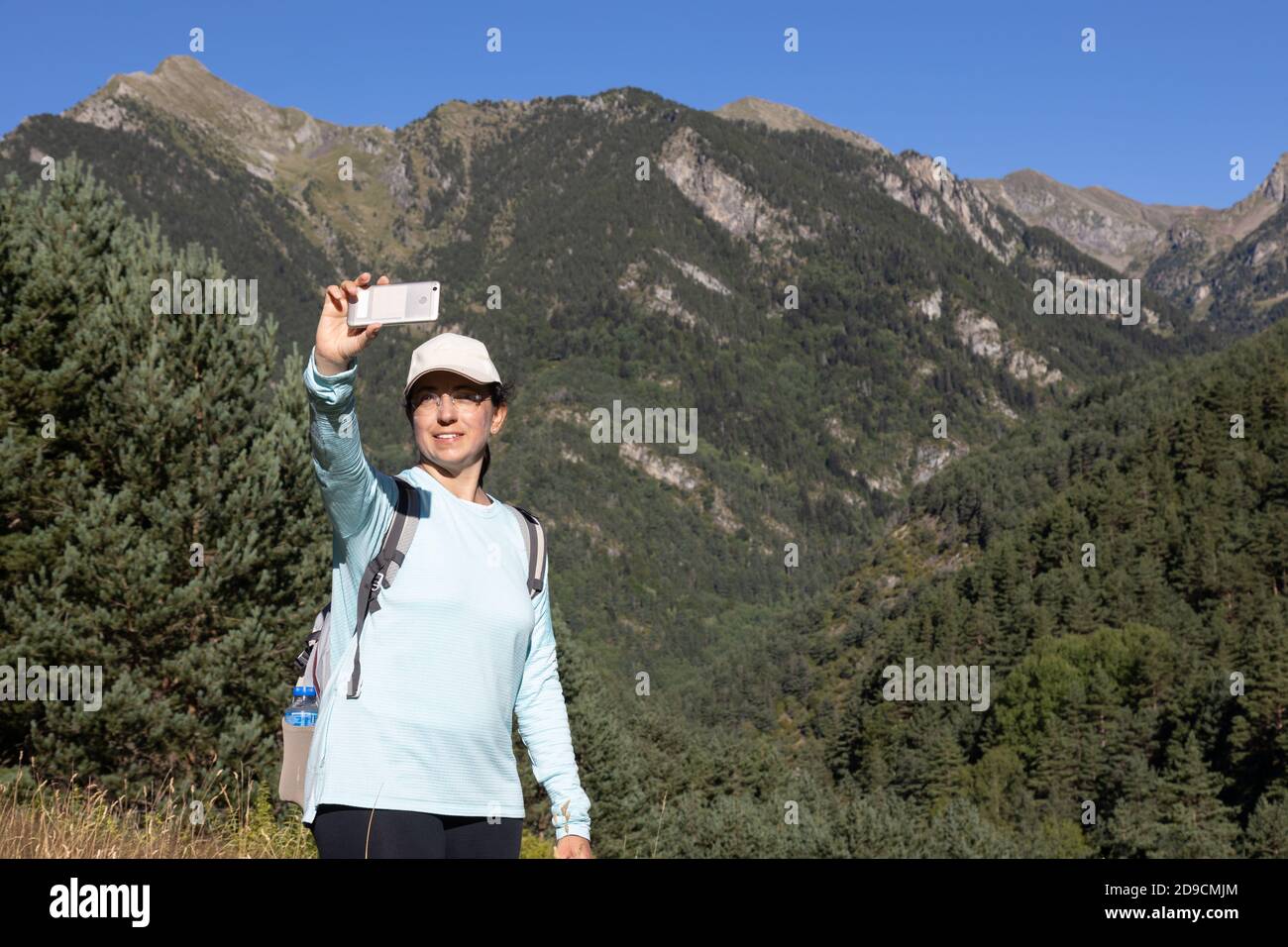 Giovane turista scatta una foto dalla montagna con il cellulare telefono Foto Stock