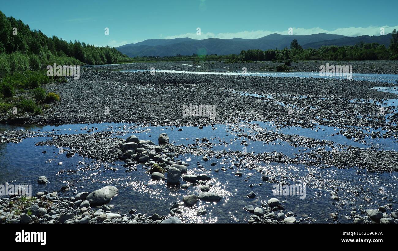 Luce del sole sul fiume Waiohine con la catena Tararua sullo sfondo, Greytown NZ Foto Stock