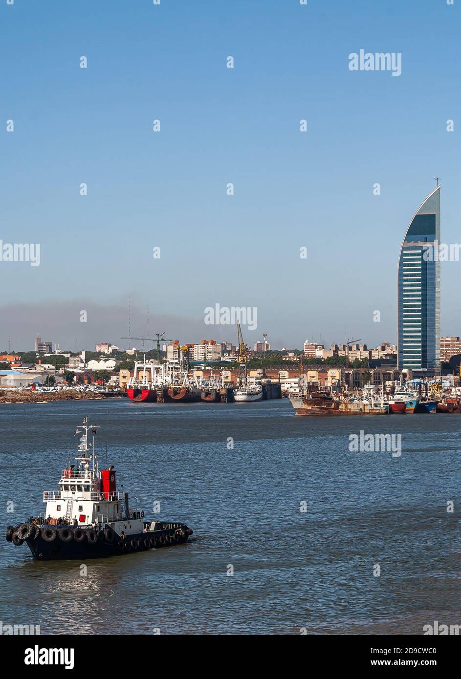 Montevideo, Uruguay - 18 dicembre 2008: Porto con navi da pesca e rimorchiatore di fronte al blu e argento Joaquin Torres Garcia Torre di ANTEL Telecom Foto Stock