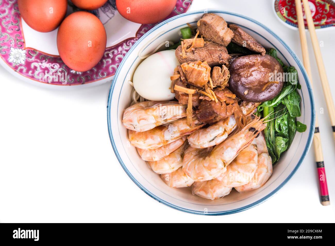 Ciotola di noodle di compleanno cinese con frutti di mare, carne, uova rosse Foto Stock