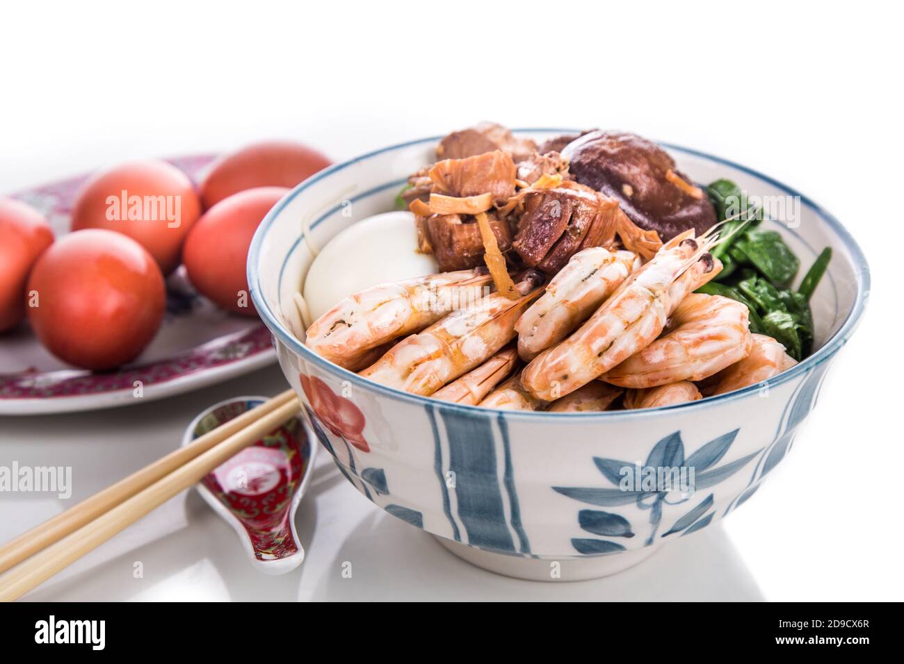 Ciotola di noodle di compleanno cinese con frutti di mare, carne, uova rosse Foto Stock