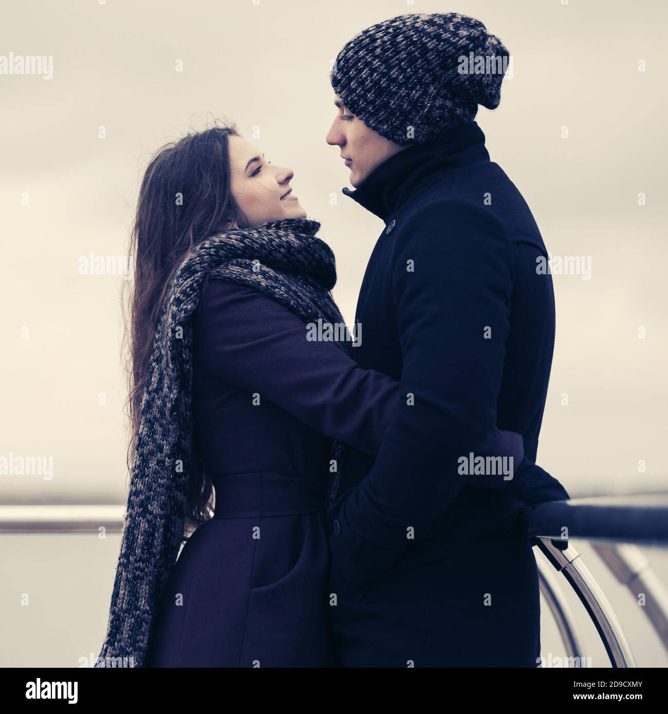 Felice moda giovane coppia in amore abbracciando outdoor elegante uomo e donna che indossa cappotti classico beanie e sciarpa Foto Stock