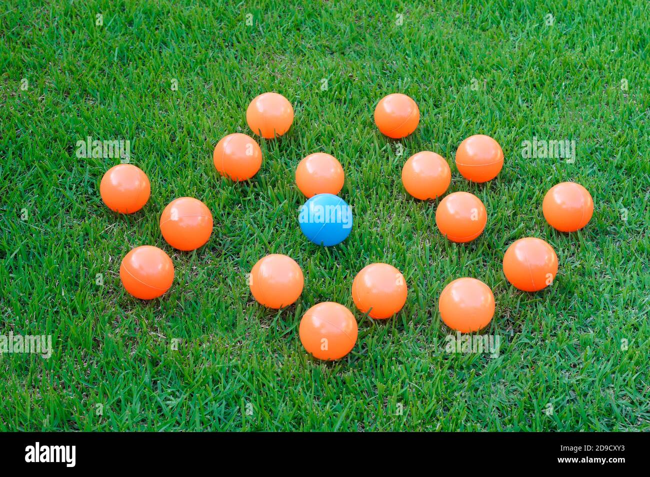 Palline colorate di plastica intorno ad un altro - concetto di bullismo Foto Stock
