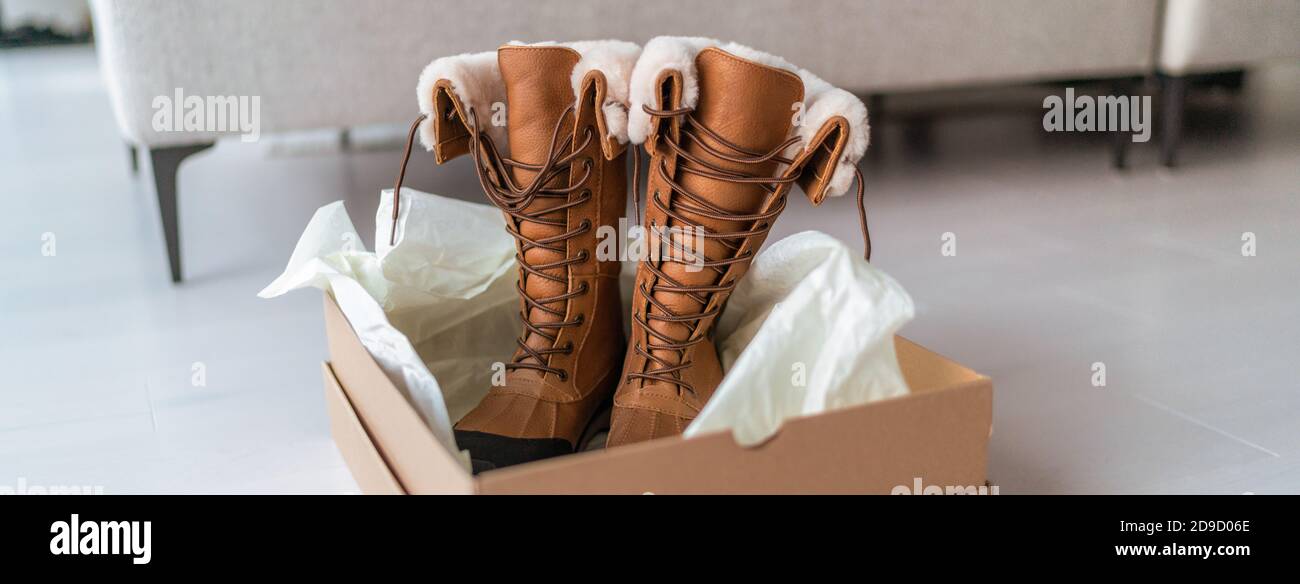 Nuovi stivali invernali acquistare nuove scarpe da trekking online shopping e consegna. Apertura della cassetta delle scarpe nel soggiorno di casa Foto Stock