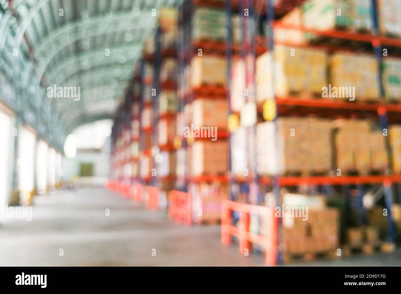 Scaffali di magazzino defocati con scatole di cartoni come sfondo Foto Stock