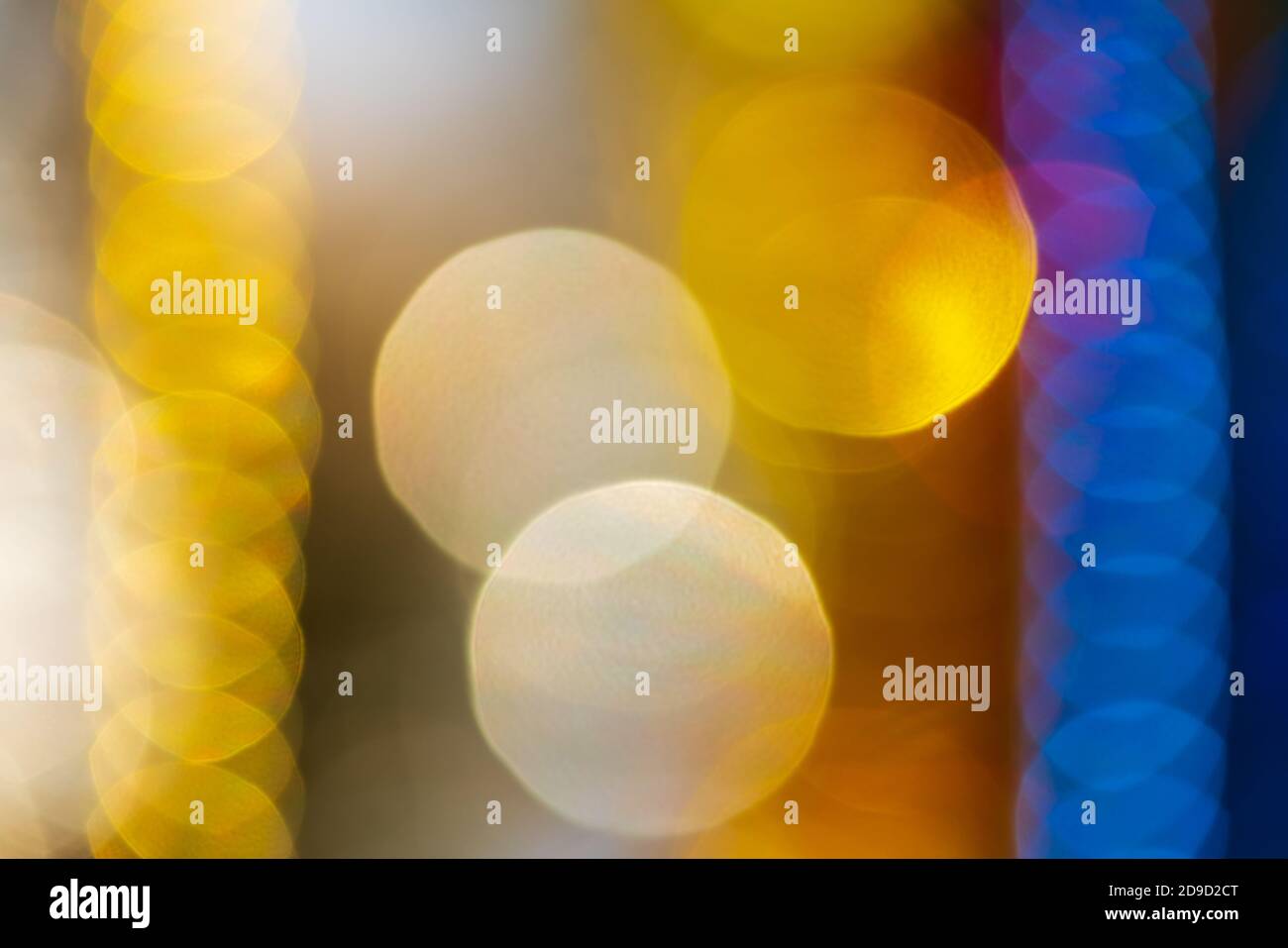 Luminoso sfocato astratto sfondo bokeh sfocato. Decorazioni ornamentali natalizie di colore giallo e blu. Luci di Capodanno felice fuori dal fuoco, m Foto Stock