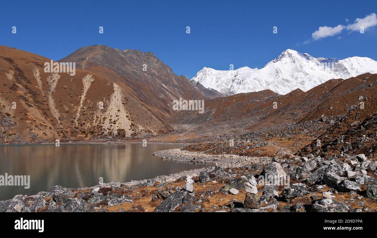 Campo roccioso roccioso roccioso a riva del secondo lago su tre passi Trek nella valle di Gokyo, regione di Khumbu, Himalaya, Nepal con maestose montagne ghiacciate. Foto Stock