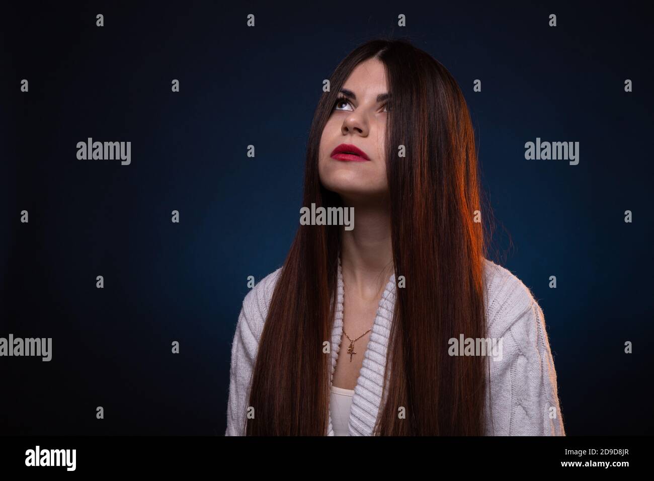 Foto di guardare la giovane donna bruna con i capelli lunghi e labbra rosse Foto Stock