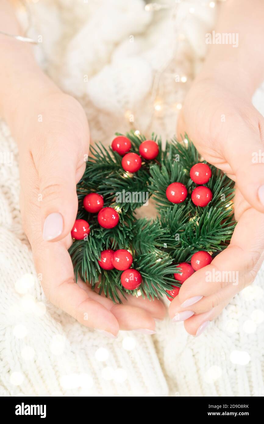 Composizione di Natale. Sfondo invernale. Corona di Natale. Corona fatta a mano per le vacanze nelle mani Foto Stock