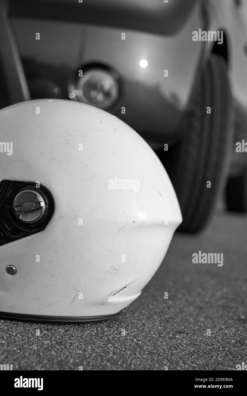 Foto del casco per auto e moto sulla strada, il concetto di incidenti stradali, foto in bianco e nero. Foto Stock