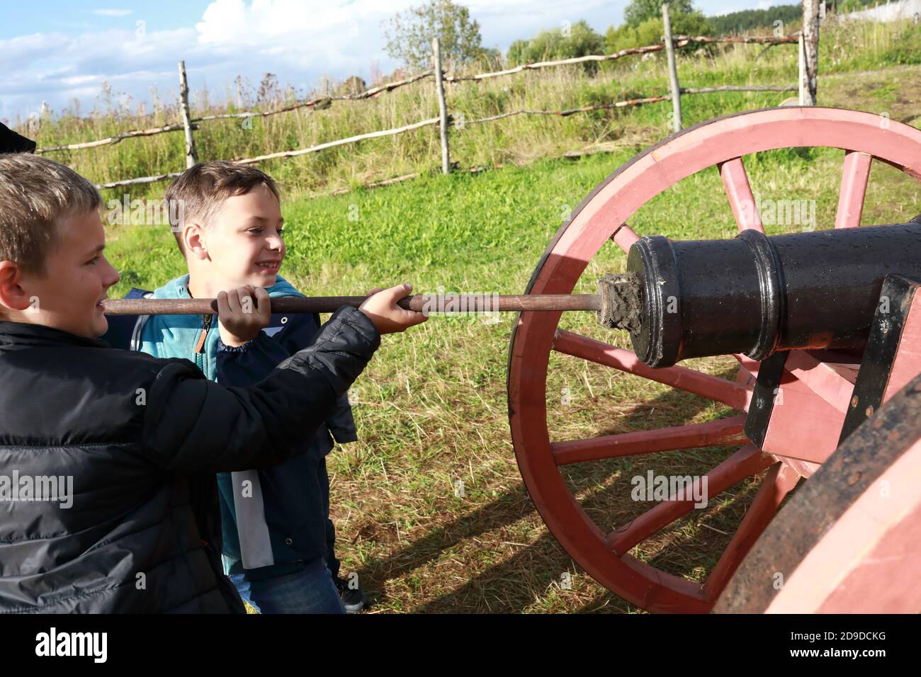 I bambini caricano un cannone antico in estate Foto Stock
