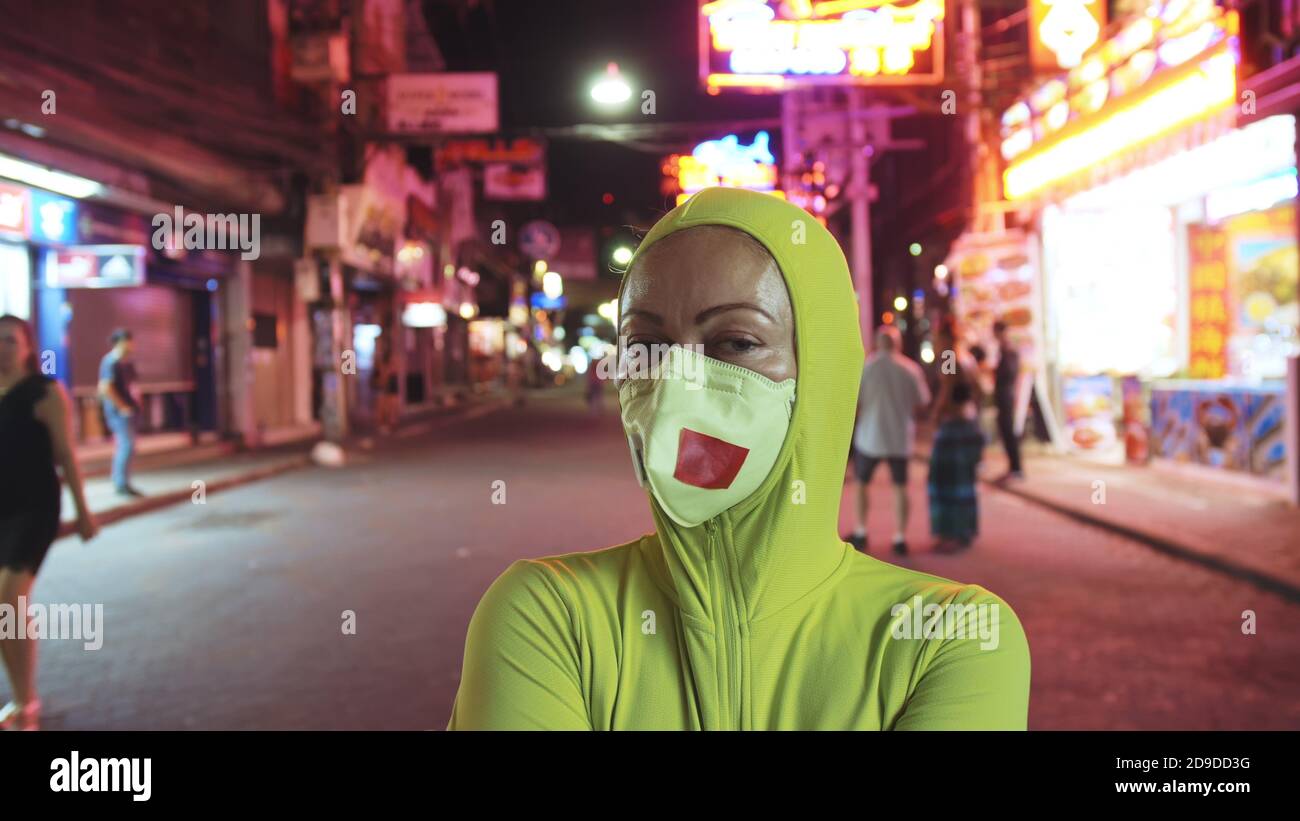 Donna primo piano guardare caucasico a Pattaya Walking Street con indossare maschera medica protettiva. Isolamento quarantena blocco. Coronavirus covid-19. Foto Stock