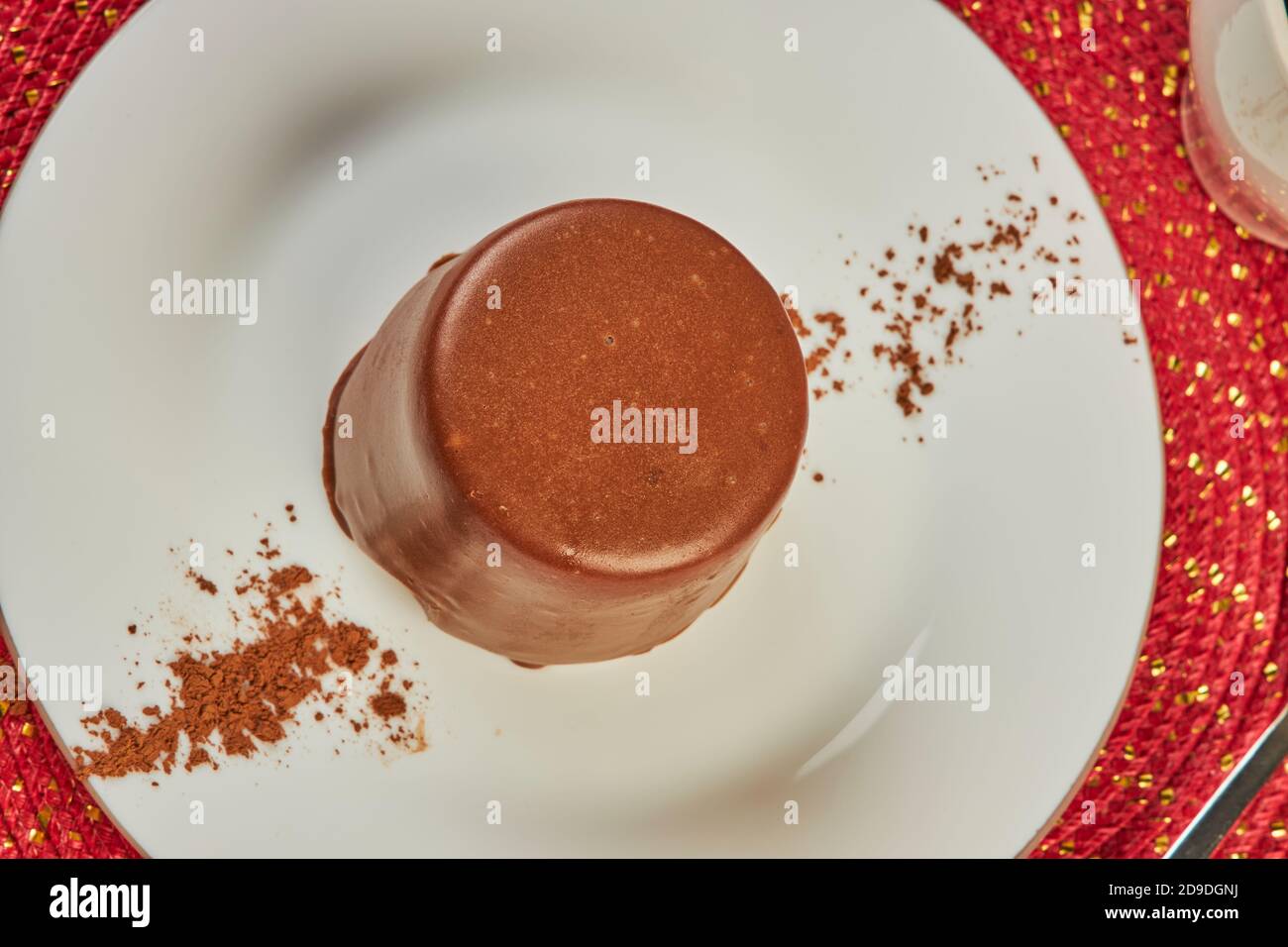 Mini dolce di lusso coperto con glassa di cioccolato sulla tavolo in caffetteria Foto Stock