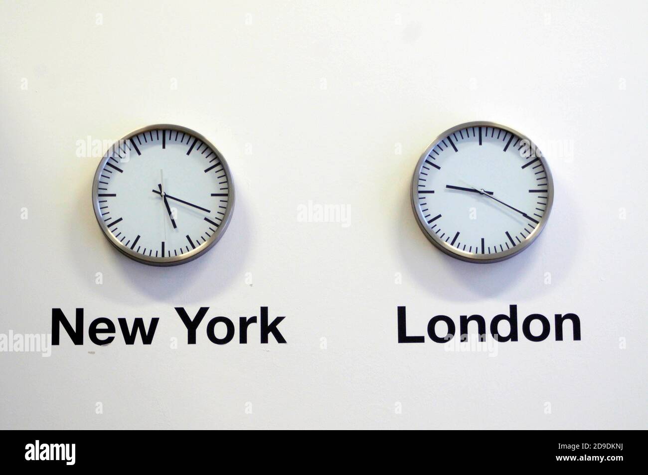 Due orologi che mostrano diversi fusi orari per New York e. Londra Foto Stock