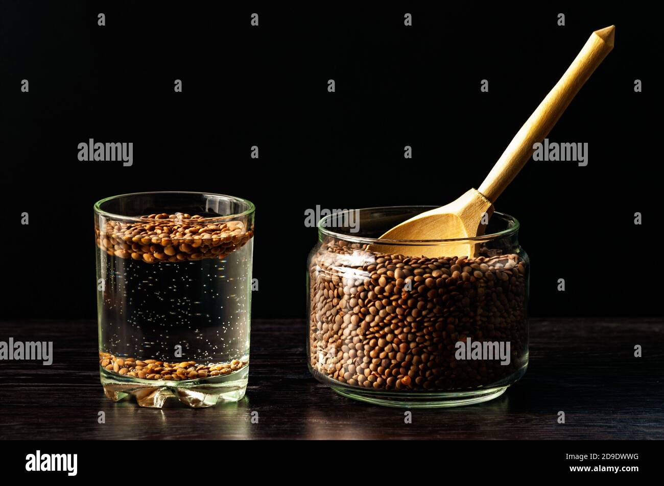 i fagioli di lenticchia sono bagnati in un bicchiere d'acqua. preparazione per germogliare le lenticchie Foto Stock