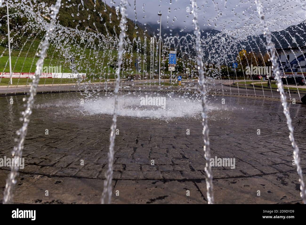 Gocce congelate di acqua in caduta di una fontana su un rotonda Foto Stock