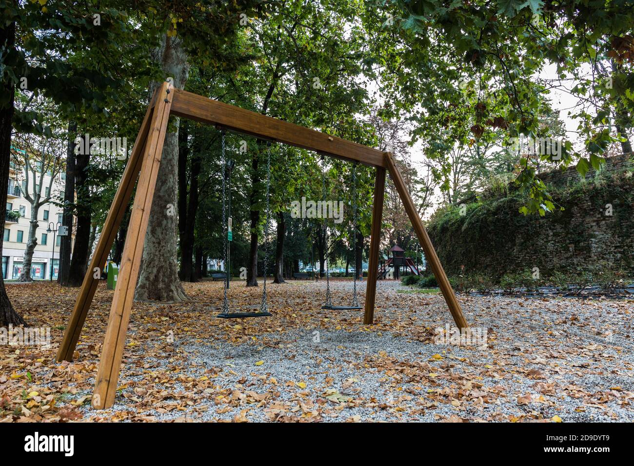 Altalena vuota per i bambini in un parco con foglie cadute. Umore autunnale Foto Stock