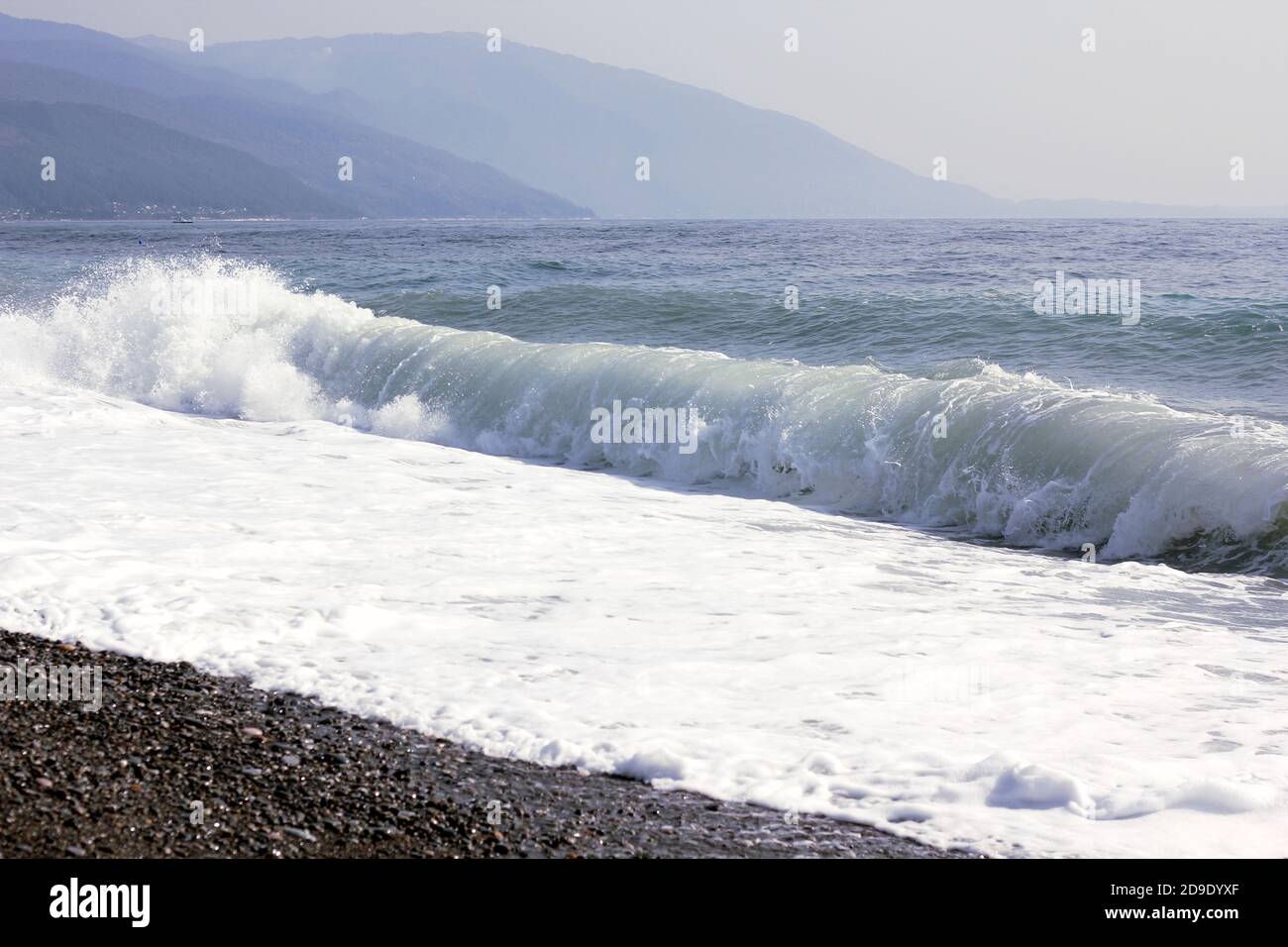 grandi onde sul mare nero sullo sfondo di montagne Foto Stock