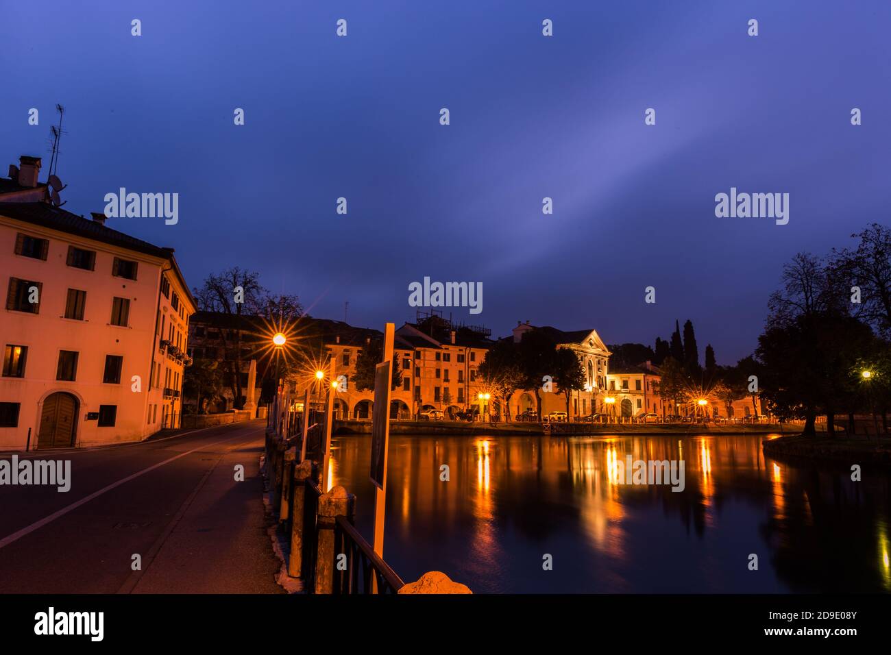 Vista pittoresca sul fiume Sile nel centro della città Con luci riflessi sull'acqua di notte Treviso Italia Foto Stock
