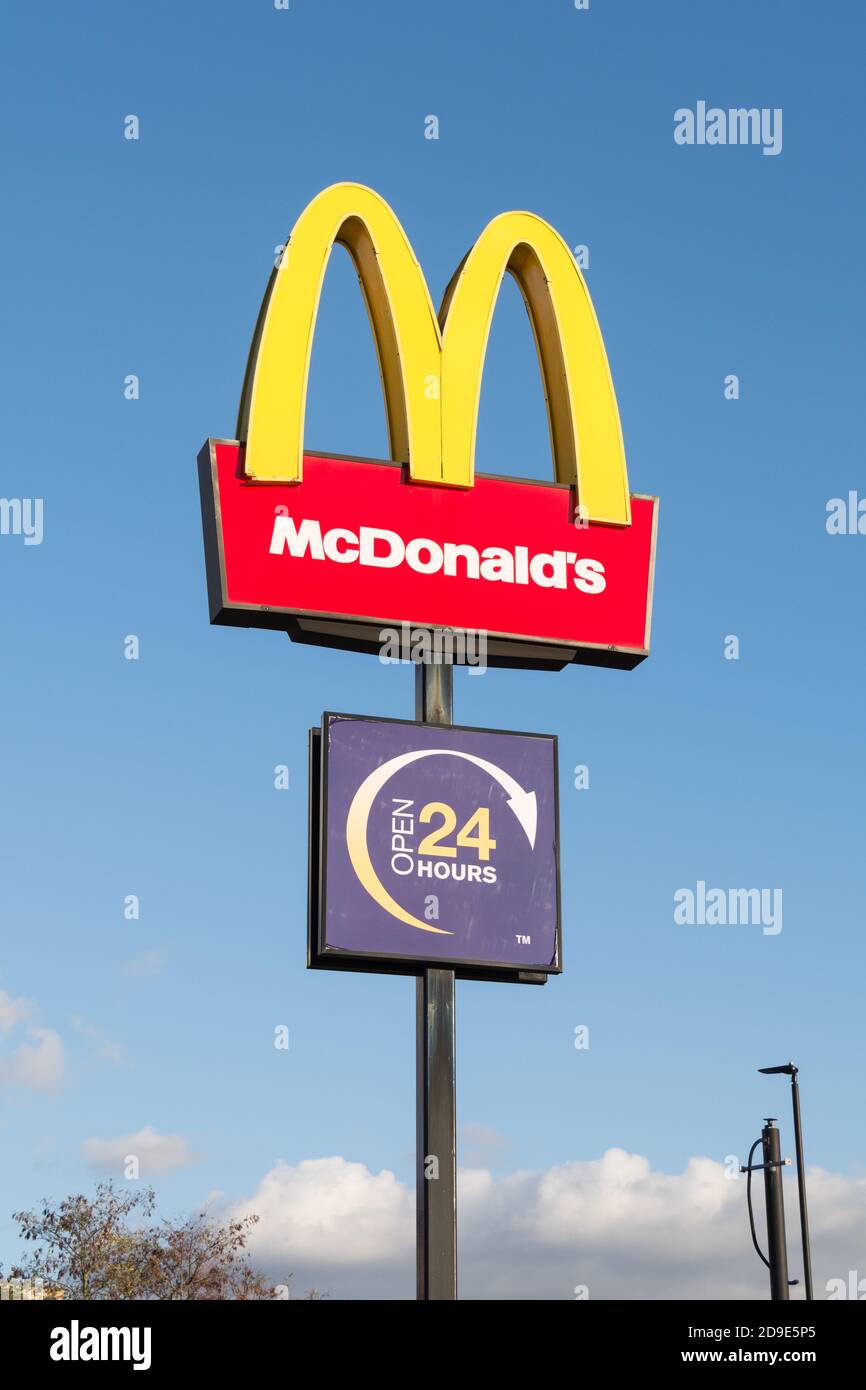 Il logo McDonald's e il cartello degli archi dorati si trovano contro un cielo blu all'esterno di un outlet a Wandsworth, Londra, Regno Unito Foto Stock