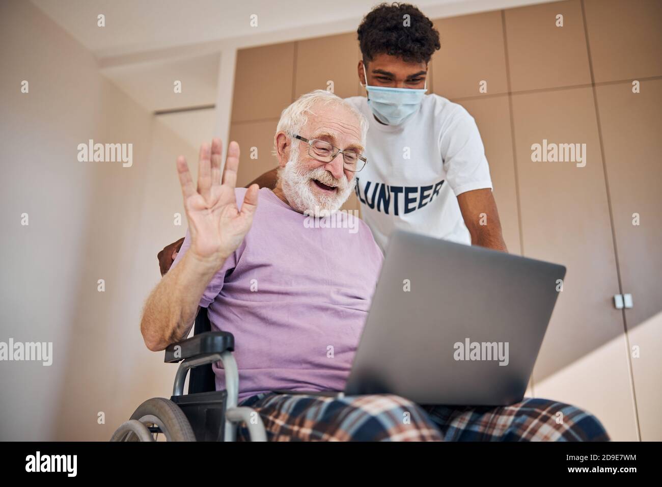 Allegro uomo anziano che saluta il suo amico via Skype Foto Stock