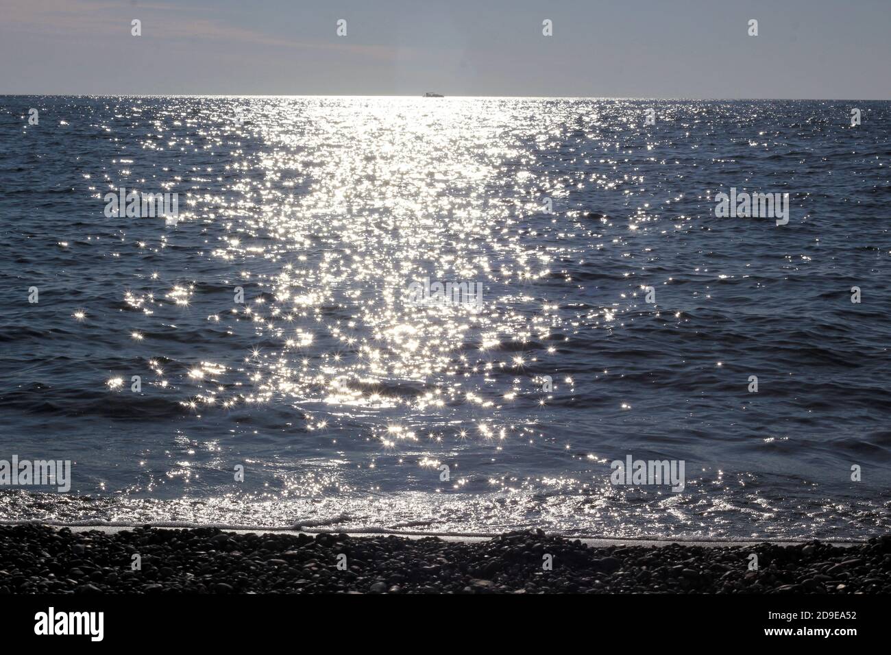 i raggi del sole si riflettono nel mare nero Foto Stock