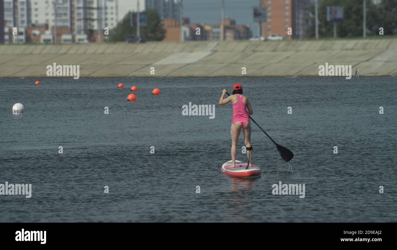 Atleta in stand up paddleboard sup paddle tenendo la scheda paddleboarding gara. SUP tavola da surf. Foto Stock