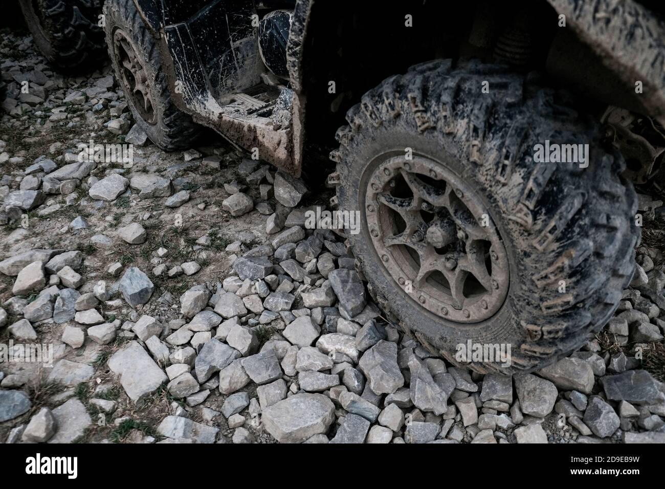 Vista in primo piano del fangoso sporco pneumatico quad. Trasporto fuoristrada estremo per uno stile di vita avventuroso. Sporcizia sugli pneumatici dopo aver guidato nel fango. Foto Stock